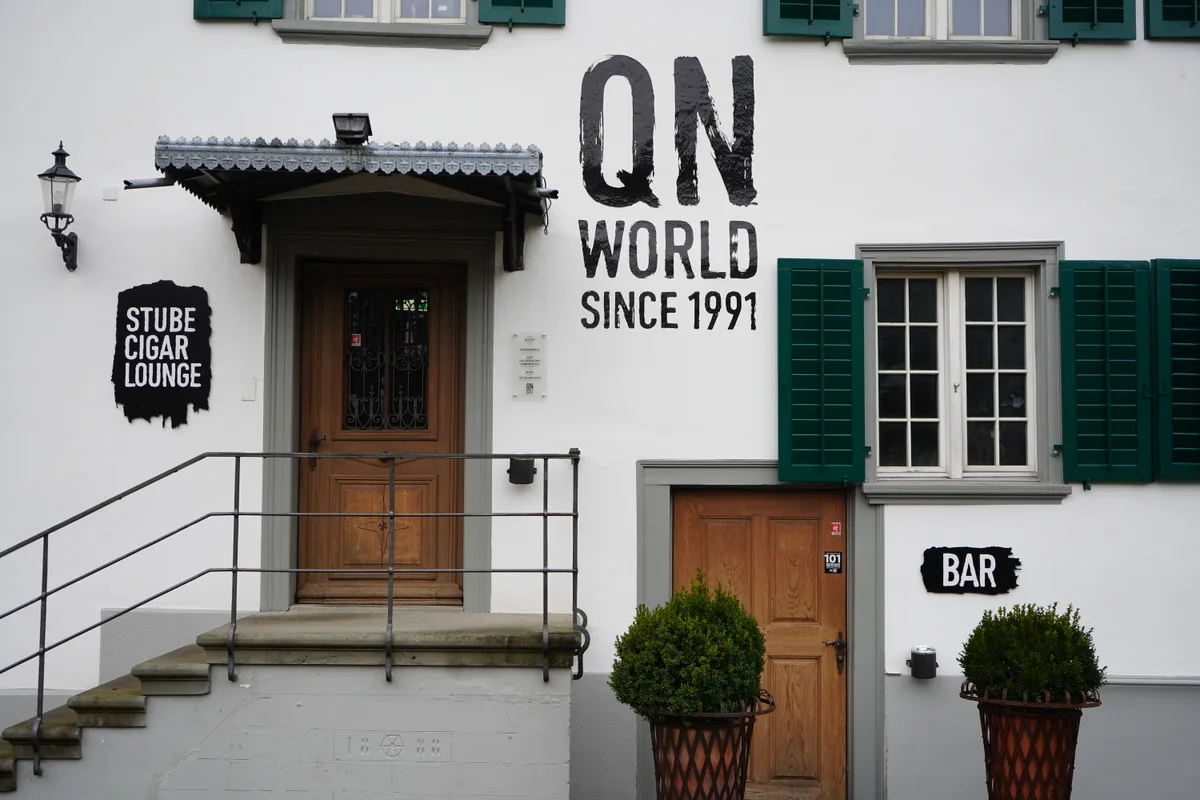 Das «QN» in Effretikon von aussen. Man sieht eine Treppe, die zu einer Eingangstür führt. An der Wand steht «QN World – since 1991».